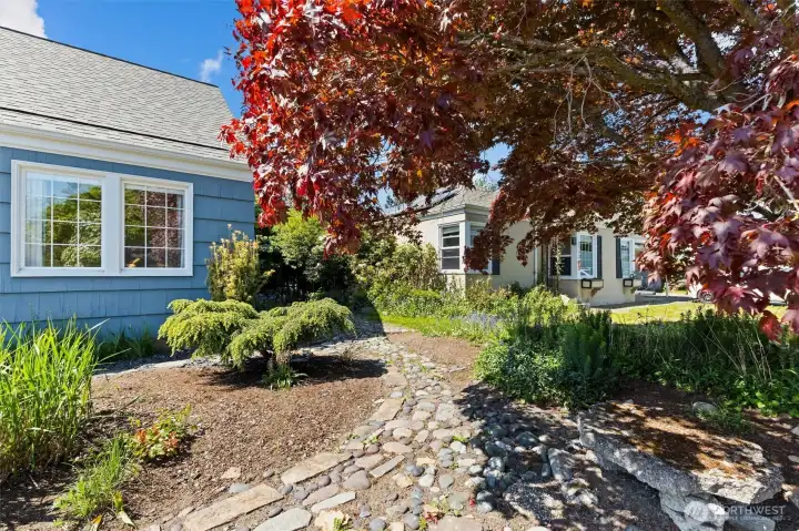 Charming front garden entry with mature Japanese maple, stone pathways, and established plantings.