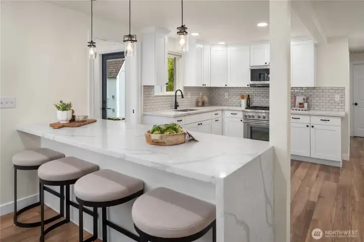 The spacious breakfast bar easily seats 4 with a waterfall quartz detail seen on the right.