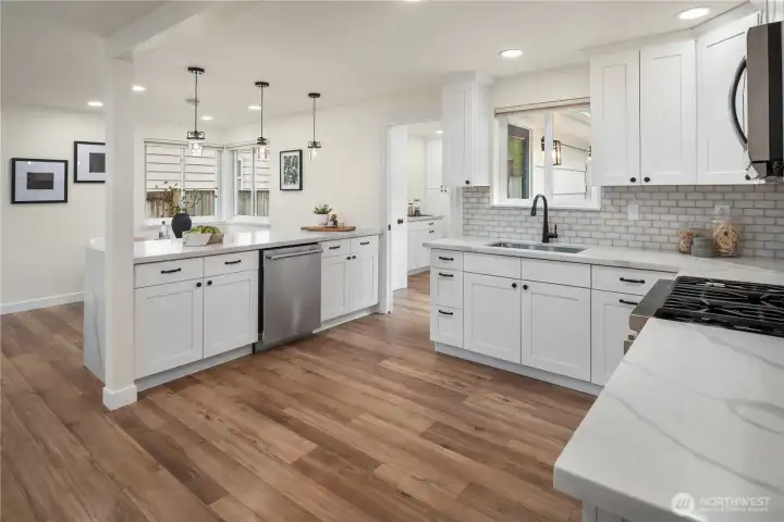 Looking across this massive kitchen you can share the cooking duties with multiple sous chefs. Full height cabinets and a tiled backsplash give the kitchen a sleek look that is also practical.