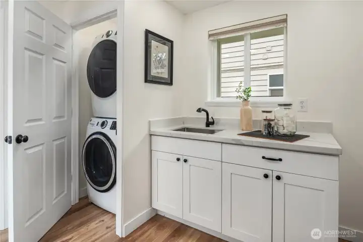 A full size stack washer and dryer are discreetely located in a quiet place.