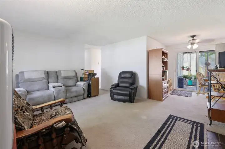 Living room is open to dinning area. Gas fireplace to the right of photo. Fantastic extension of living space through sliding door with fully enclosed sunroom.