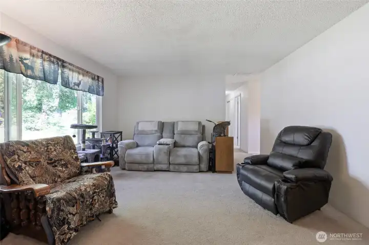 Oversized front window brings the greenery of the front yard and natural light into the home.