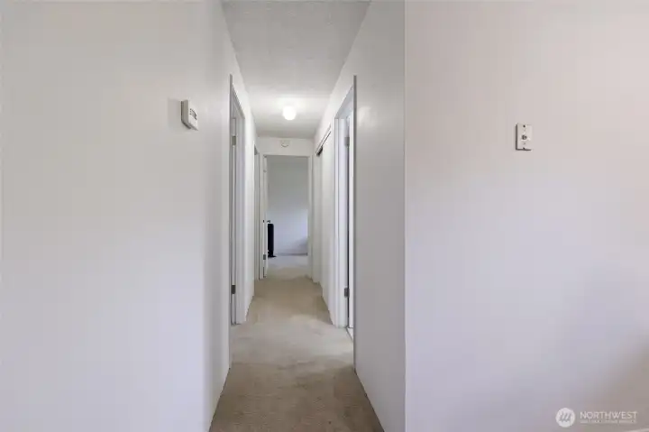Hallway leads to 3 bedrooms and full bathroom