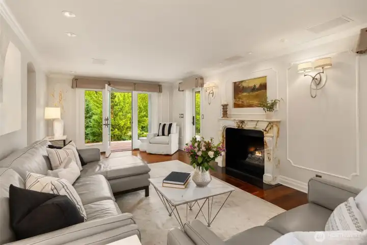 This light-filled living room is anchored by a stunning, authentic Parisian marble fireplace mantel dating back over a century.