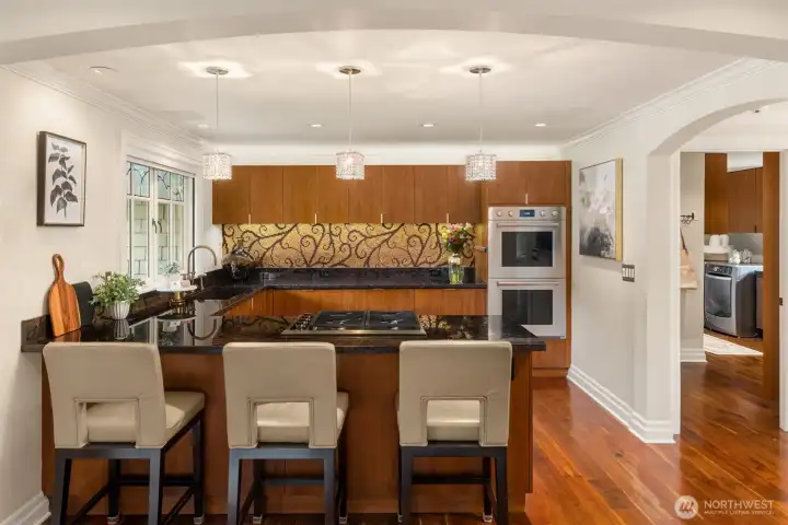 This elegant kitchen features superb finishes and high-end appliances, including a two-drawer dishwasher, an ice maker, a cabinet-integrated refrigerator, dual ovens, and a propane cooktop.