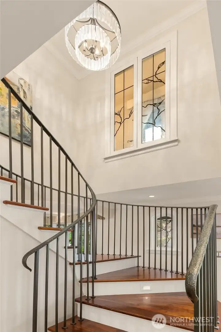Staircase view showcasing the custom Mesolini glass windows in the primary suite.