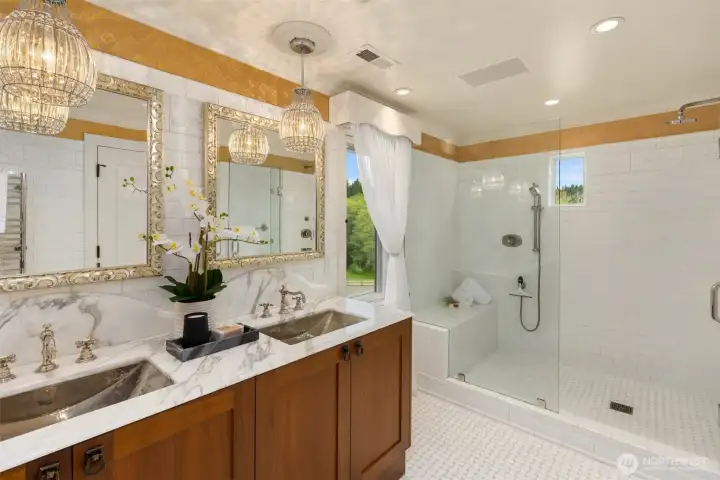 The primary bath features extensive tile work, radiant heated flooring, premium Waterworks fixtures, and custom-framed mirrors crafted by Wildfire Productions of Bainbridge Island.