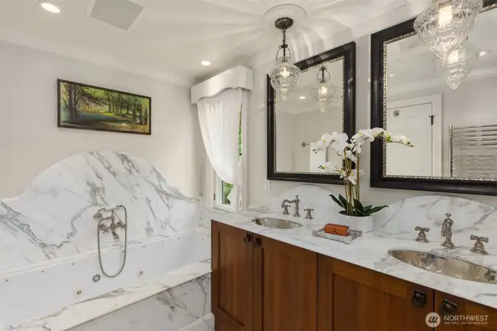 The hall bathroom features exquisite marble finishes and premium fixtures from Waterworks.