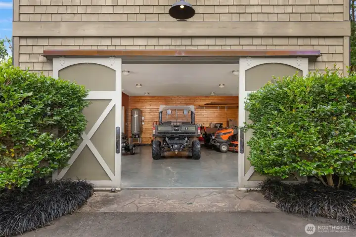 The equipment garage is situated on the ground level of the Tree House, which also features an attached single-car garage and a heated horse bathing station with hot and cold water access.