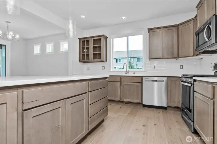 Great kitchen layout with quartz counters and a full backsplash. Great kitchen layout with quartz counters and a full backsplash.