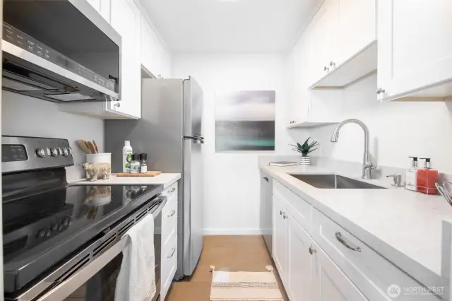 Completely remodeled bath with quartz counters and stainless steel appliances.