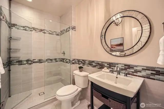 Bathroom 3, located on the main level, features a designer-tiled shower, custom vanity, and stylish designer lighting for a refined, modern touch.