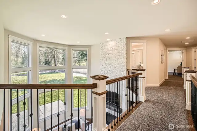 Delightful upper-level catwalk overlooks the grand foyer on one side and the dramatic two-story family room on the other, adding architectural charm and openness.