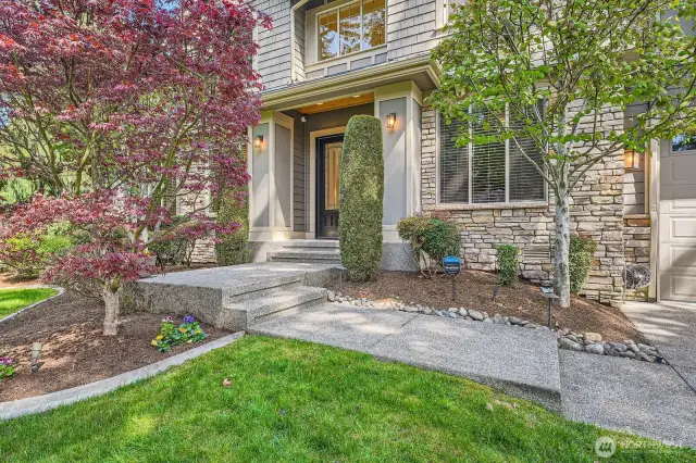 Blooming trees and beautifully landscaped grounds surround the exterior entry area.