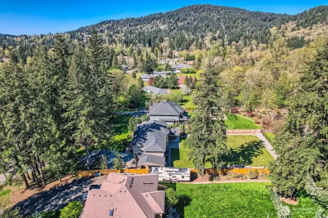 Aerial view showcasing the featured property and adjacent homes built by the same high-quality builder. This continuity adds to the neighborhood’s cohesive aesthetic and contributes to long-term property value. A thoughtfully developed setting with consistent architecture and pride of ownership throughout.