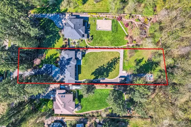 Aerial view of the immediate neighborhood, highlighting the featured property and surrounding homes. Set in a peaceful community with vibrant spring blooms, occasional winter snowfall, and regular visits from local deer. A tranquil, nature-rich setting that offers year-round beauty and a welcoming sense of home.