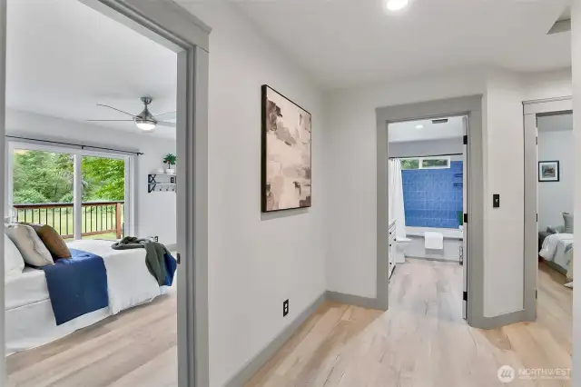 Hallway view.  Primary bedroom to the left, guest bath in center and BR 2 at right.