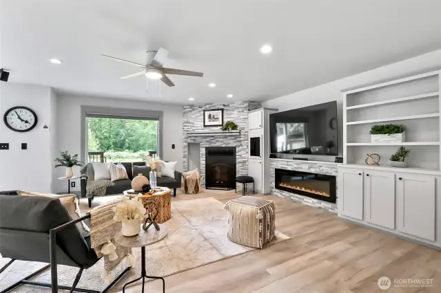 This room features a wood burning stove and an electric fireplace.
