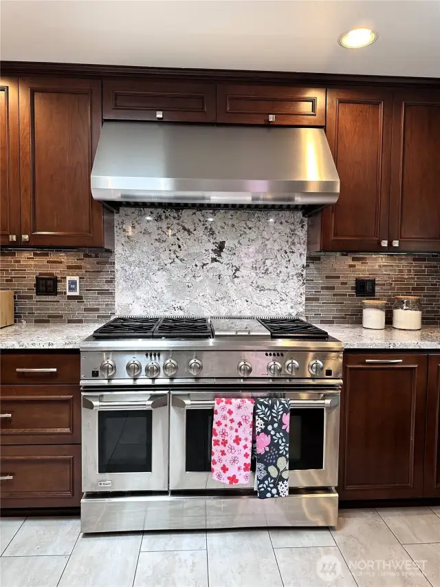 Beautiful.   56" GE Monogram commercial 6 burner stove with built in griddle, double oven & matching exhaust hood.