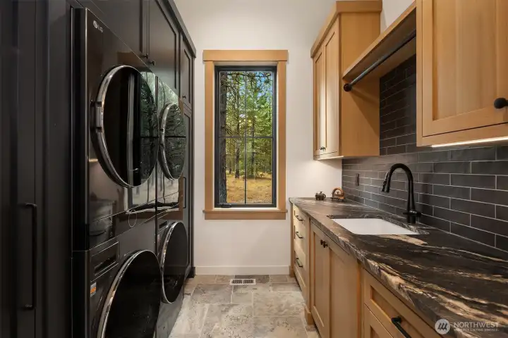 downstairs laundry room offers two sets of washers and dryers