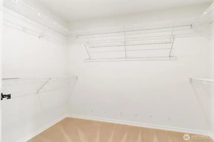 Large walk-in closet with built-in shelving and excellent organization.