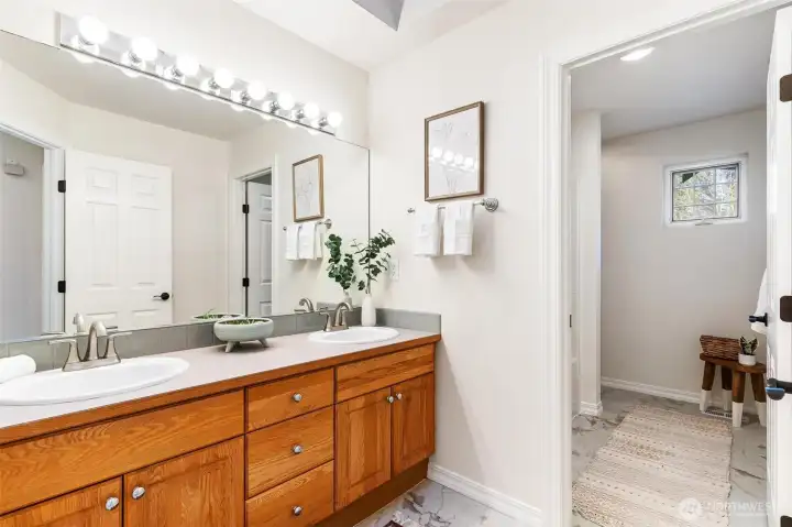 Extended dual-sink vanity with warm wood cabinetry and ample storage.