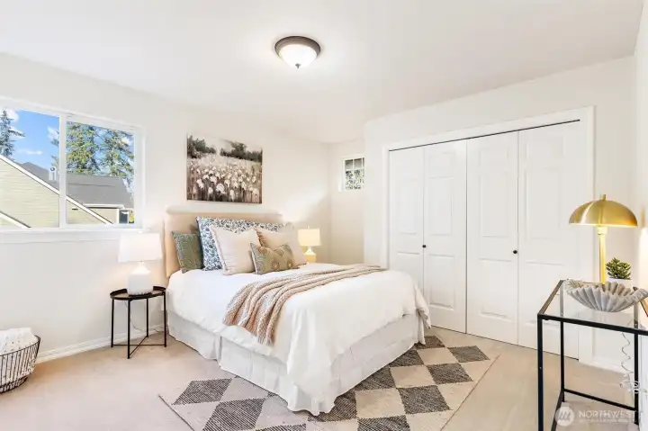 Well-sized bedroom with large window and comfortable living space.