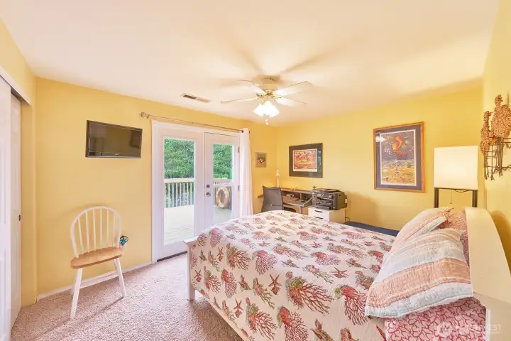 Second upstairs bedroom with French doors leading to the canal-view deck—perfect for morning coffee.