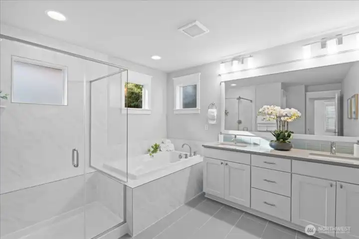 The primary bathroom en-suite features a double vanity with quartz counters, a soaking tub and oversized walk-in shower. Beautiful tile flooring and finishes make this spa-like bathroom a calming space that you will love to get ready in each day.