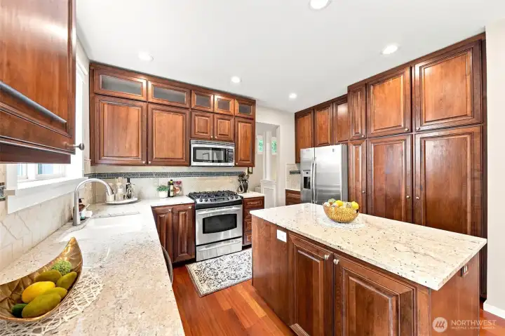 The kitchen has granite countertops and cherry cabinetry and floors.