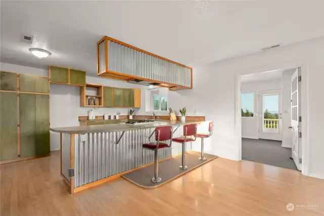 Trendy kitchen with Mid-Century built -n Barstools, custom breakfast bar and cabinetry.