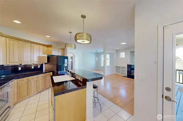 From the additional dining space, enjoy a clear view into the open living and dining areas. To the right, a door leads to a spacious entertainment-sized deck with stunning golf course views.