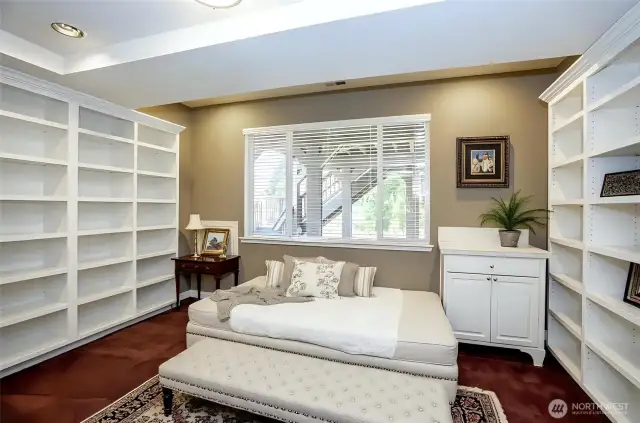 Spacious lower-level bonus room, thoughtfully designed with built-in shelving - virtually staged for inspiration.