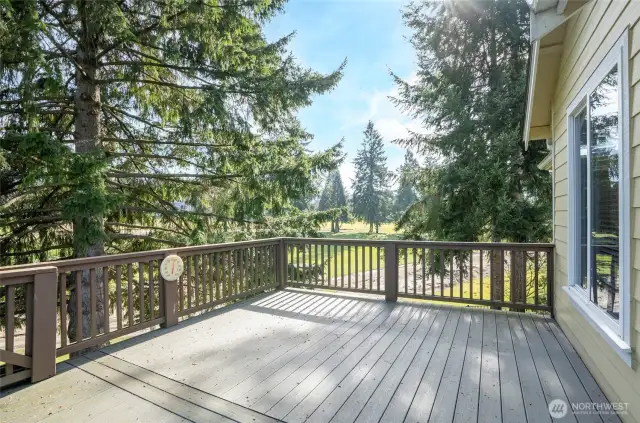 Spacious deck located off the kitchen, showcasing stunning panoramic views of the golf course.