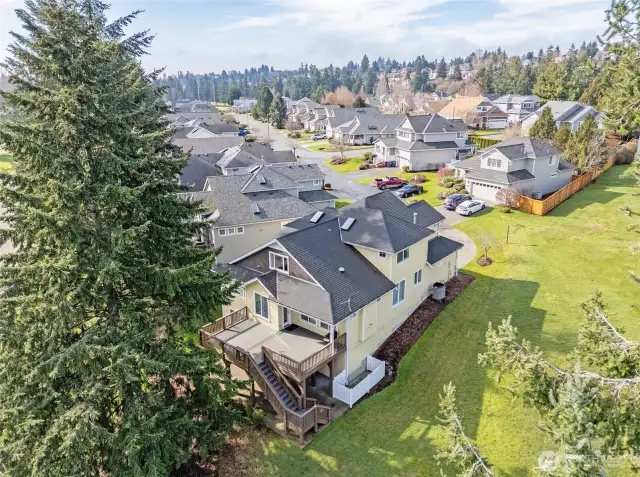 Aerial view of the home showcasing the expansive deck and the beautifully landscaped grounds that surround the property.