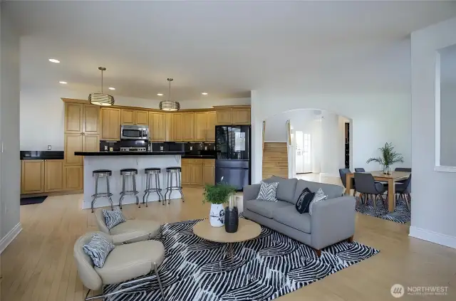 From the living area, enjoy a seamless view into the stylish kitchen, complete with a spacious extra eating bar. The rich hardwood floors transition effortlessly into elegant ceramic tile, enhancing the home's flow and charm - virtually staged.