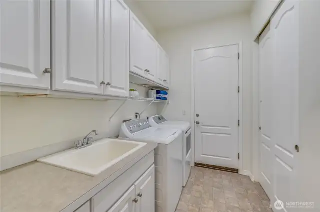 Laundry room with a handy sink and storage cabinets.