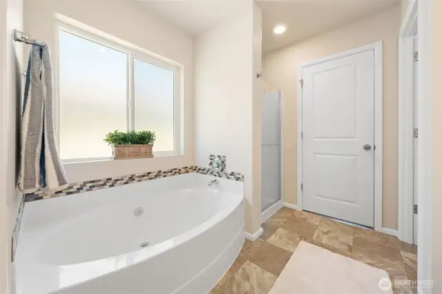 Large soaker tub with full sized window with privacy glass allows you to bathe in light while you relax.