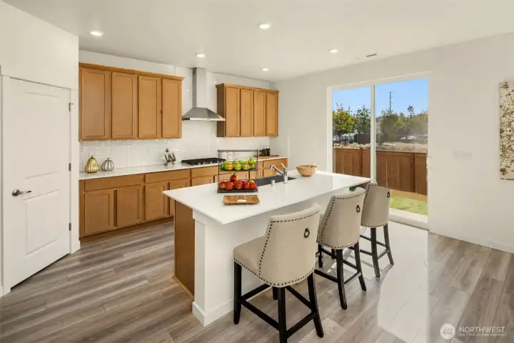 A gourmet kitchen with slider door leading out to the backyard area