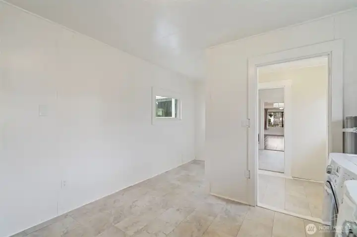 View from utility room to exterior door and kitchen.