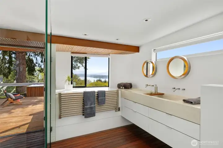 Spa-like setting with dual vanity, heated towel rack and warm wood floors