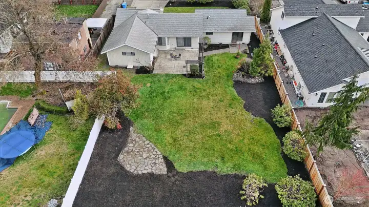 Turn-key perfection on nearly a third of an acre! This beautifully updated 1,706 sq. ft. rambler offers the ultimate in single-level living. Fresh interior and exterior paint sets a crisp, modern tone, complemented by brand-new carpet in the Great Room, bonus space, and primary suite. The heart of the home is a sun-drenched kitchen with a skylight, garden window, and solid oak cabinetry, flowing seamlessly into the open Great Room. Retreat to the primary suite featuring a private slider to the backyard, or enjoy the refreshed main bath with its new tile shower and vanity backsplash.    The exterior is an absolute showstopper: professionally landscaped grounds with a large hardscape patio, wood trellis, and a secondary stone patio for fire-pit nights. With a freshly cleaned roof and gutters, brand-new washer/dryer, and a fully-fenced backyard with western exposure, this home is truly move-in ready. Welcome home!