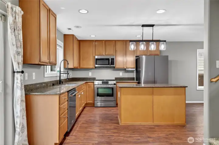 CHEF’S KITCHEN  Open and spacious with center island with granite counters & lots of work space, with drawers and storage area  Recessed lighting / Granite counters / Easy maintenance wood floors