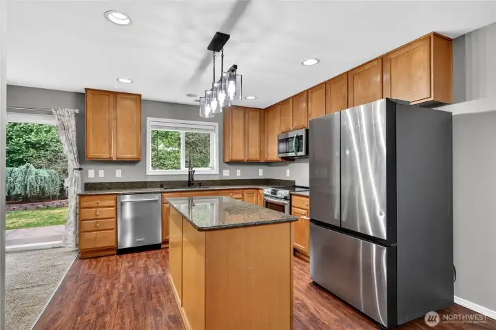 Dual stainless sinks with spray faucet, overlooking lovely rear yard  Samsung Stainless side by side frig with freezer drawer & ice maker  Frigidare Stainless oven with induction stove top   Kitchenaid Stainless dishwasher
