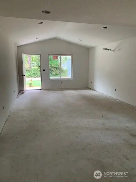 Light filled great room with a tall ceiling and recessed lighting. LVP hardwood floor to be added soon. Light filled great room with a tall ceiling and recessed lighting. LVP hardwood floor to be added soon.