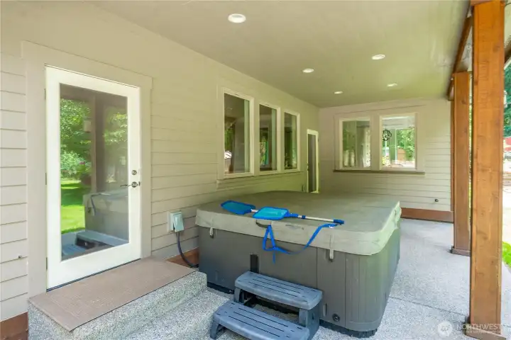 Covered back patio with hot tub