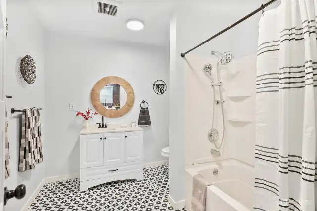 Large updated bathroom with linen and towel storage.