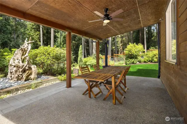 The covered patio has direct access to the three car garage. It also has a wood burning stove, allowing for outdoor dining during the cold season.