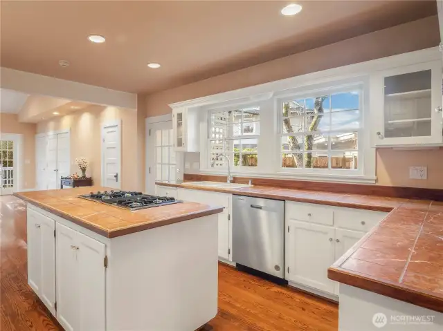 Nice sized kitchen with custom built cabinets, tile countertops, and gas stove.