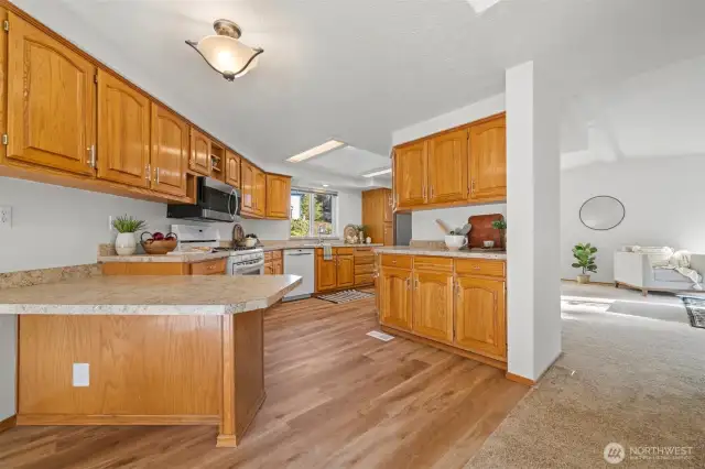 Bar seating area on the left. NEW luxury vinyl flooring throughout the kitchen. NEW light fixture.